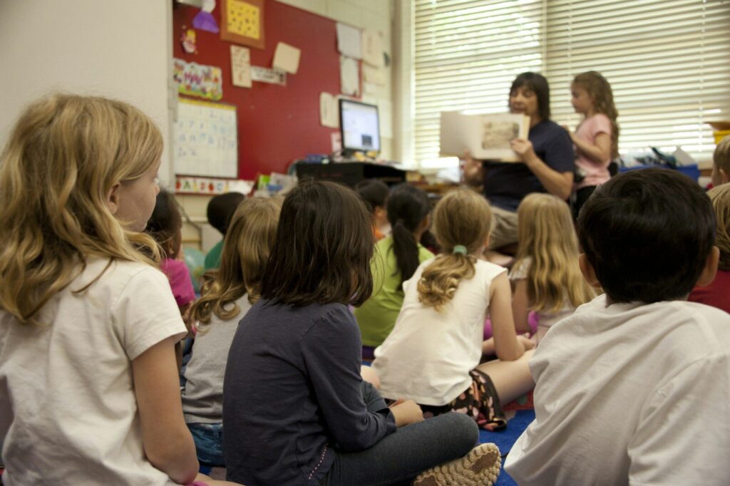 A group of children sitting on a classroom floor listening to a story