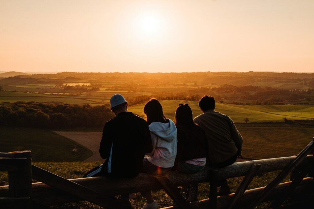 a group of people sitting on top of a wooden bench
